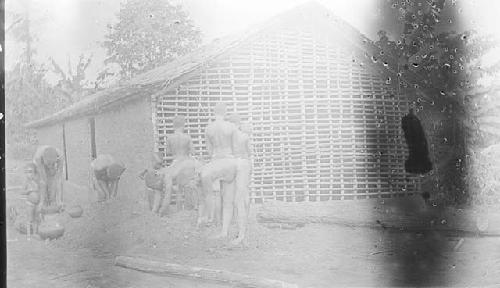 Hut construction process, People putting mud on hut