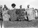 Men displaying decorative war shields