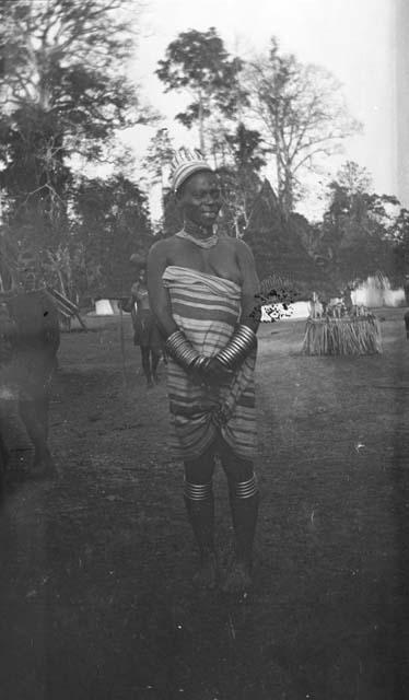 Woman in dress and jewelry, including bangles, calf ornaments