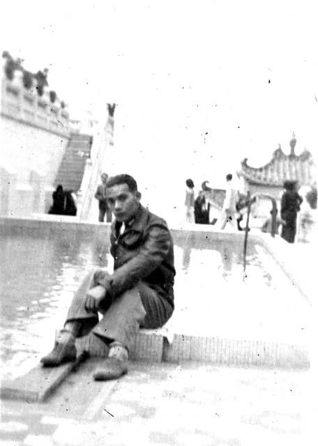 Man sitting in front of fountain pool