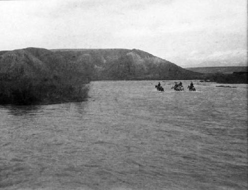 Four horsemen fording river