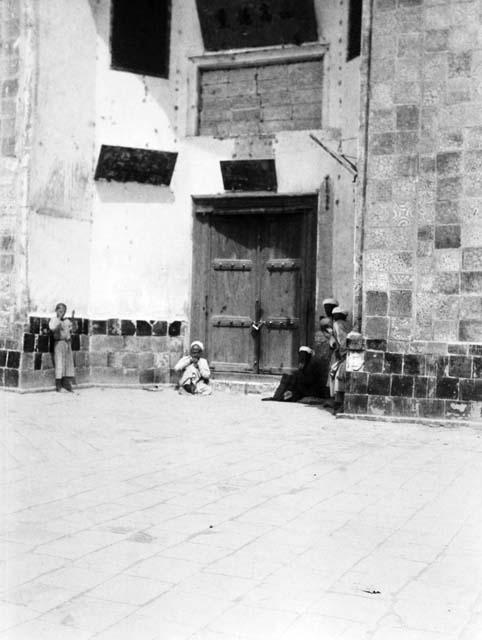 Doorway with Chinese inscriptions, four old men standing or sitting in entryway