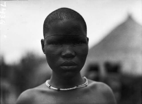 Frontal view of young girl with necklace and facial scar tattooing