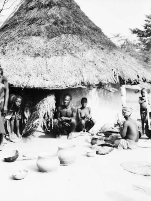 Group watching woman making clay pots