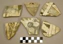 Ceramic, sherds, black designs on white, one with anthropomorphic figure