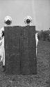 Two men holding carved wooden door panels