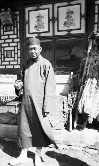 Man standing in front of a building wearing long robe and cap