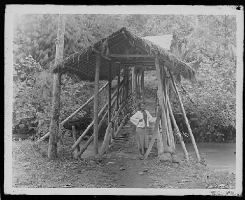 Woman standing by causeway over river