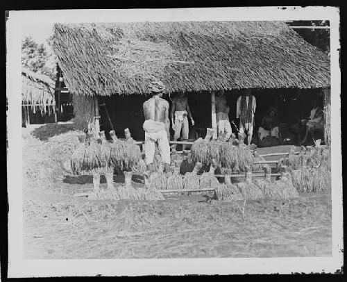 Men in front of hut in rural setting