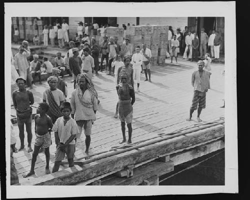 Men and children standing on dock