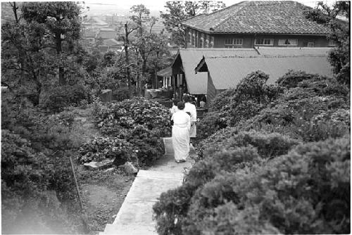 Women walking down a pathway towards a building