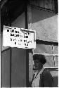 Woman standing beneath a sign