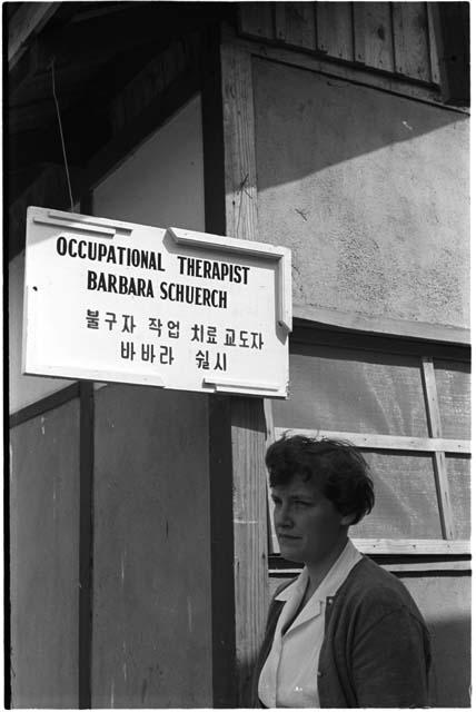 Woman standing beneath a sign