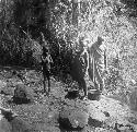 Masai children filling gourds at stream
