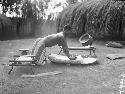 Woman grinding grain on stone