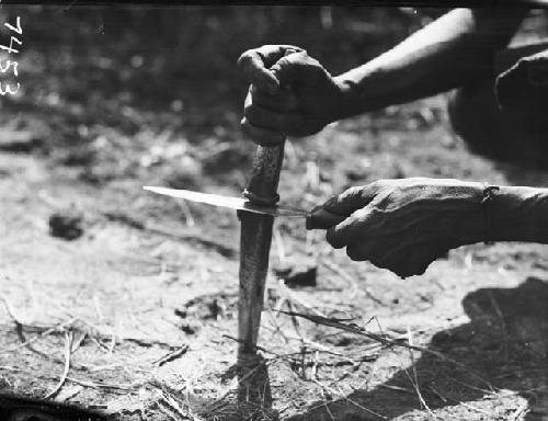 Close-up of man hammering knife