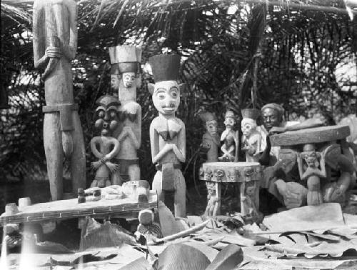 Man posing with carved wooden idols