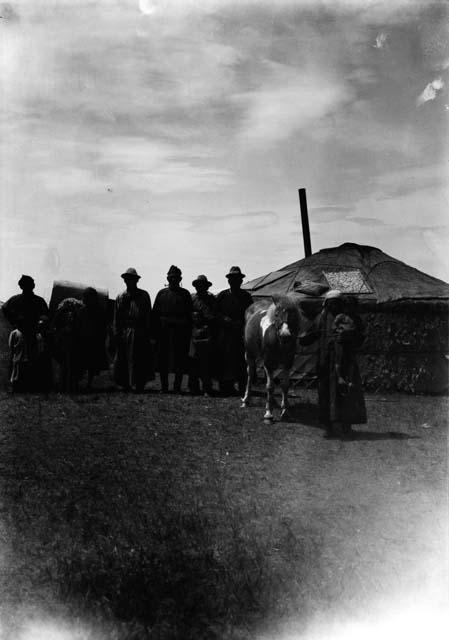 Small group of people and two horses by a yurt