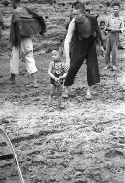 Man leaning over with arm on child in foreground