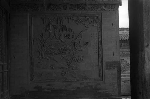 Ornate carving of landscape on stone or brick wall