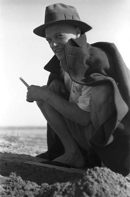 Portrait of Effie Hill in hat and coat squatting