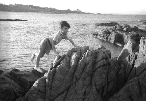 David Lattimore, climbing on rocks by seashore