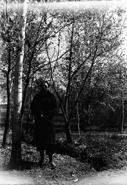 Person in Western style coat standing in forest