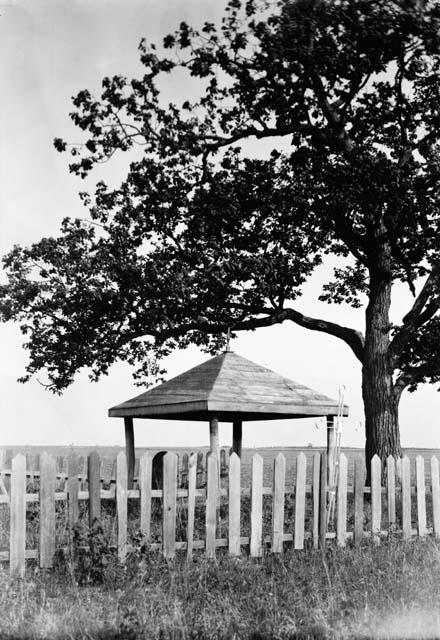 Small open structure over mound and stone marker