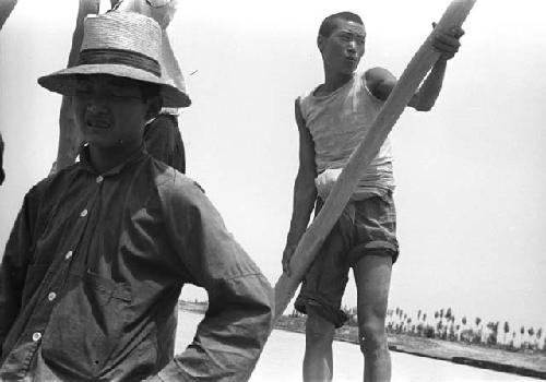 Man with pole on raft in water