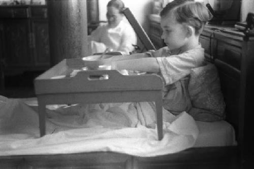 David in bed, eating with tray in front of him