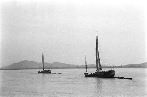 Two junks, mountains in distance