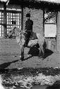 Man sitting on a horse in front of a building