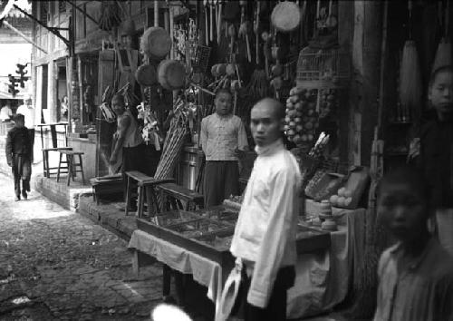 People, tables and goods lined up against building