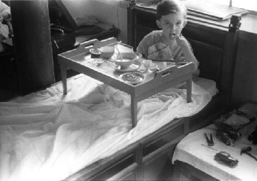 David Lattimore sitting in bed with tray of food in front of him