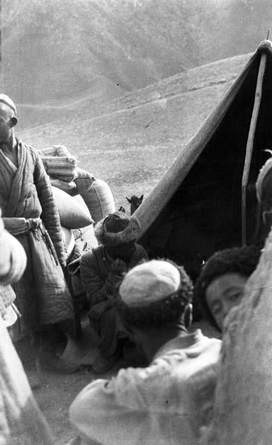 Caravan camp, several men in front of an open tent