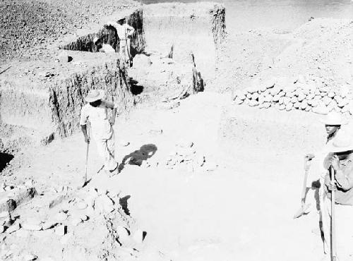 Excavation 3-31. Men digging out stone mound trench