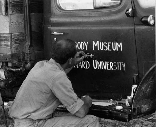 William Donnellan painting "Peabody Museum" on the expedition truck (Dodge) door