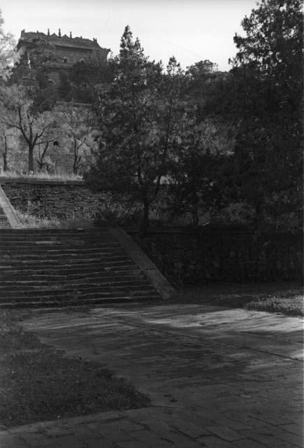 Stairway leading to wall with building(s) above and behind it