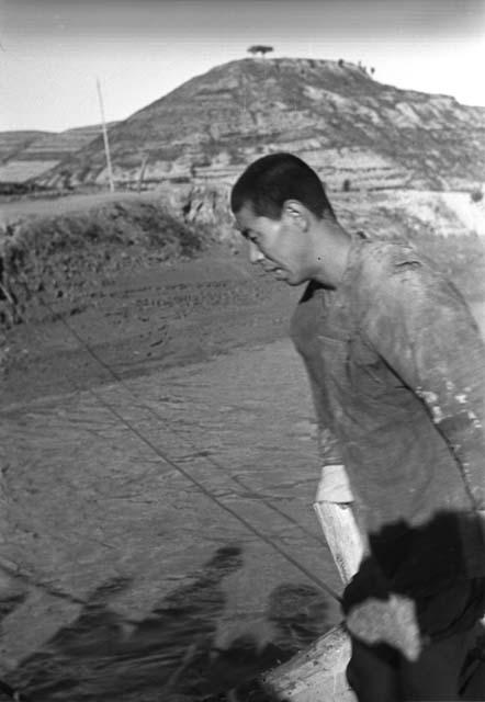 Man on boat in foreground and shadows of other people in water