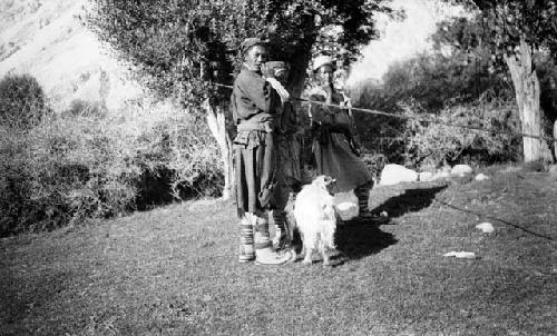 Three young men, possibly shepherds with goats in front of them