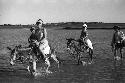 Two men walking, Eleanor Lattimore and David Lattimore riding donkeys