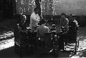 Eleanor Lattimore, two women and one man all seated at round table in courtyard