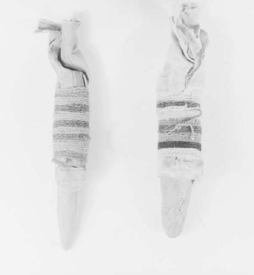 Two child's dolls of clay wrapped with cloth and thread - female