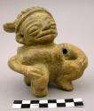 Seated humpback figurine with elaborate hairdress, hole for suspension