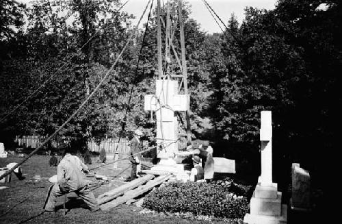 Crew installing gravestone in cemetery