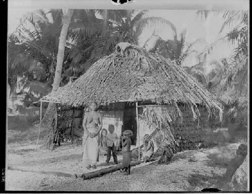 Woman and children in front of house