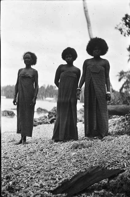 Three women in dresses on beach