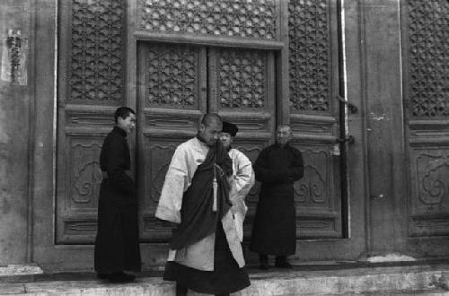 Lama in full robes, coming down steps