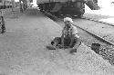 Boy sitting on platform at train stop