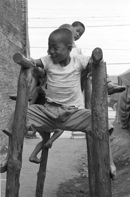 Portrait of children playing on wooden monkey bars